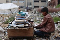 Palestinesi sfollati raccolgono libri dall'università distrutta per bruciarli e cucinare cibo