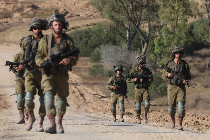 Israeli soldiers patrol along the border with the Gaza Strip