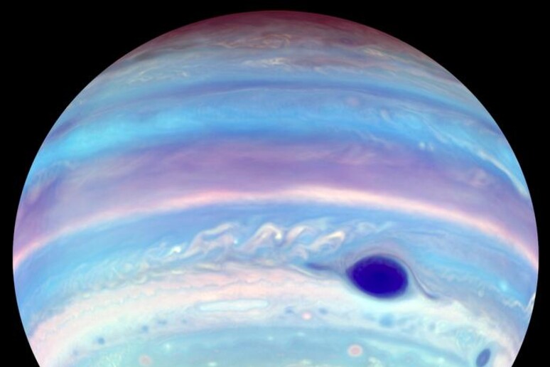 Un tornado magnetico oscura il polo Sud di Giove in un 'immagine ottenuta nei raggi UV e colorata artificialmente (fonte:&nbsp;Troy Tsubota and Michael Wong, UC Berkeley) - RIPRODUZIONE RISERVATA