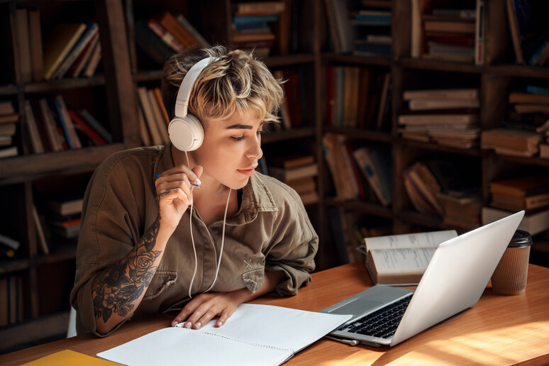 Una giovane donna studia ascoltando la musica foto iStock. - RIPRODUZIONE RISERVATA