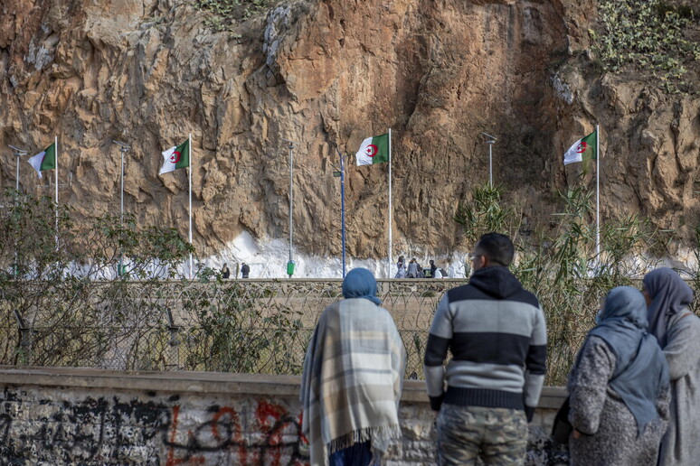 Marocchini guardano la linea di confine con l 'Algeria dalla città di Oujda - RIPRODUZIONE RISERVATA